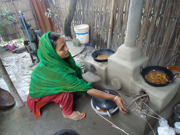 An ENRICH participant is using a health & environment-friendly cooking stove