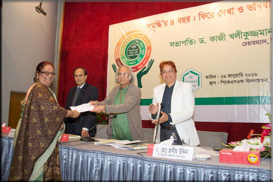 An Executive Director of an ENRICH implementing Partner Organization receiving a cheque of ENRICH programme